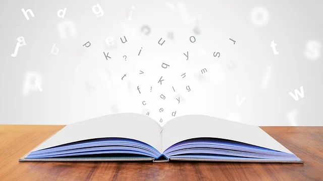 An open book with letters flying out, symbolizing knowledge or learning.