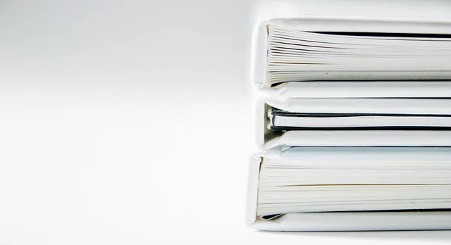 A stack of white books or notebooks on a white background.
