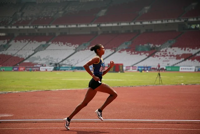 A female runner on a track in a stadium.