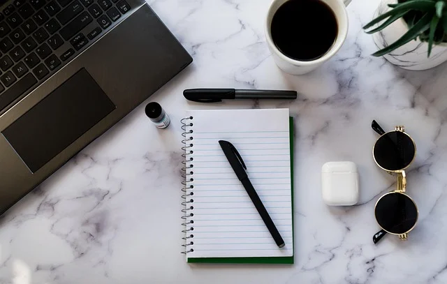 Alternating series test: Laptop, notebook, pen, and coffee cup on a marble desk