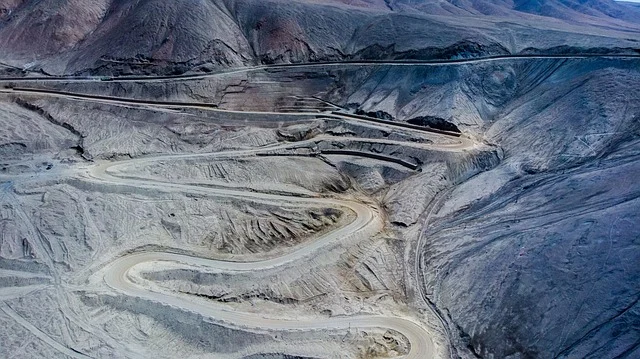 A winding road on a steep, barren mountainside, illustrating slope.