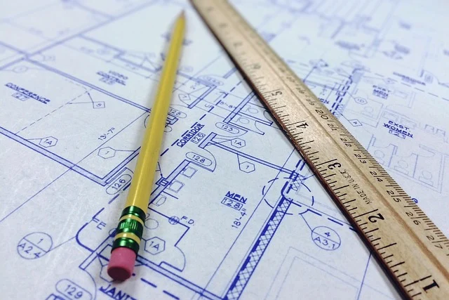 A pencil and a ruler lying on architectural blueprints
