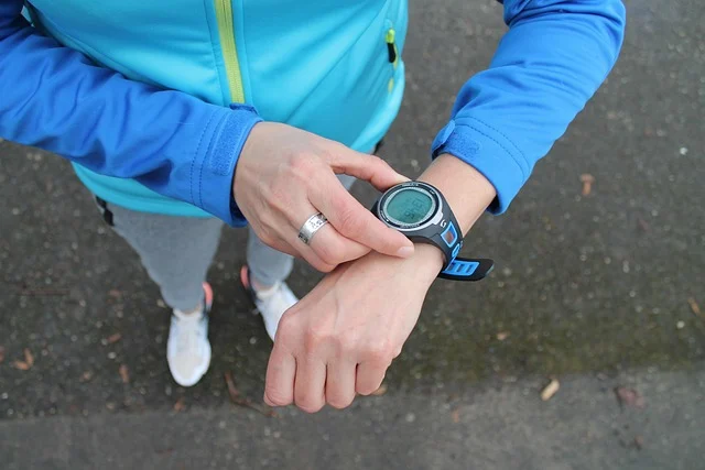 A person checking a sports watch, likely for time or distance.