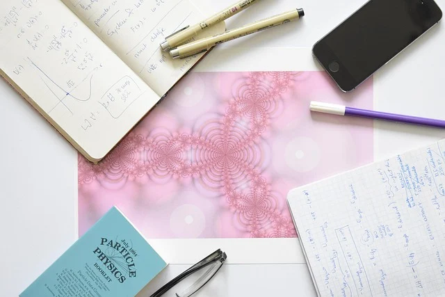 A study desk with handwritten math notebooks, pens, and a booklet