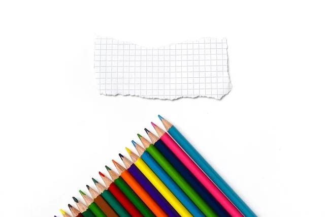 Colored pencils and a torn piece of grid paper