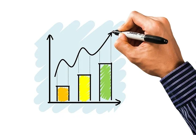 A hand drawing a graph with a curve and bar chart on a whiteboard.