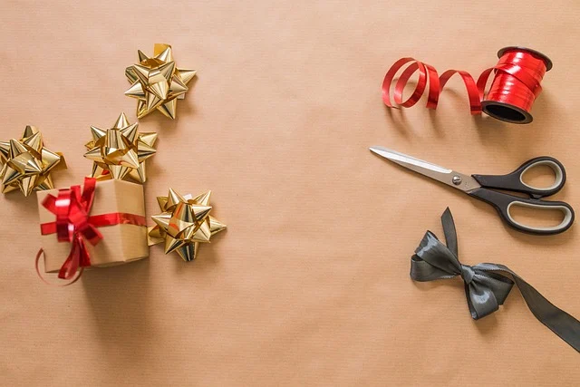 Gift wrapping supplies including bows, ribbon, scissors, and a wrapped present.