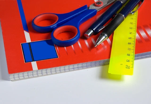 School supplies including a notebook, scissors, pens, and a ruler
