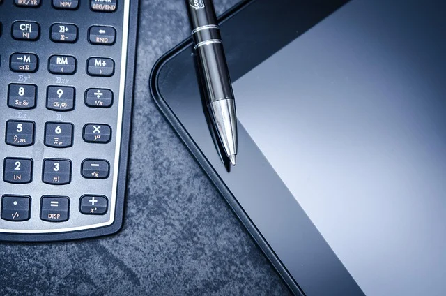 A calculator, pen, and tablet, suggesting mathematical work or study.