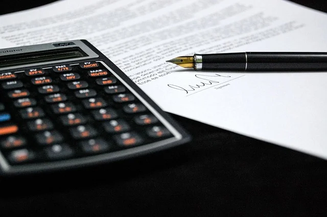Mean median mode: A calculator, a pen, and a document with a signature.