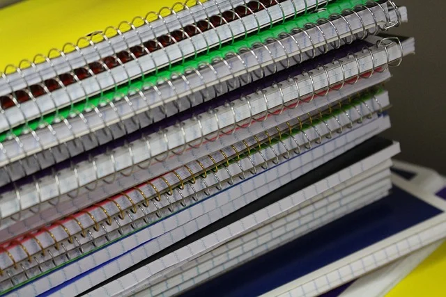 A stack of spiral-bound notebooks, suggesting study or schoolwork.