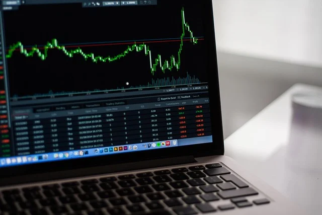 Percentage formula: A laptop displaying a stock market graph with increases and decreases.