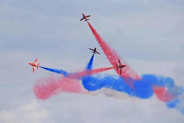 Multivariable calculus: Four planes flying in formation, leaving red and blue smoke trails.