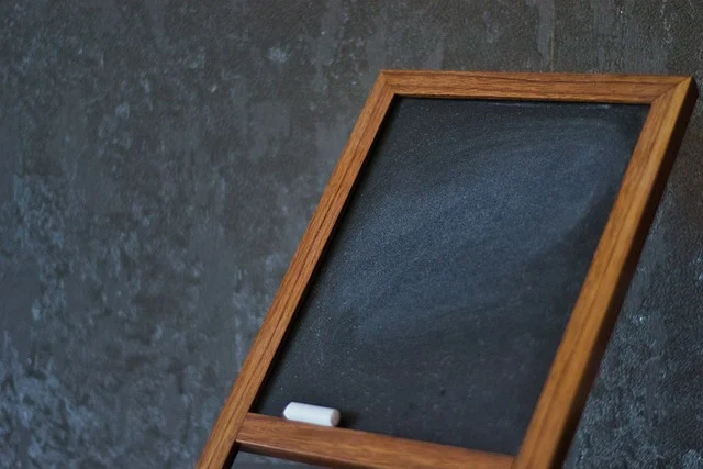 Exponent rules: A blank framed chalkboard with a piece of chalk